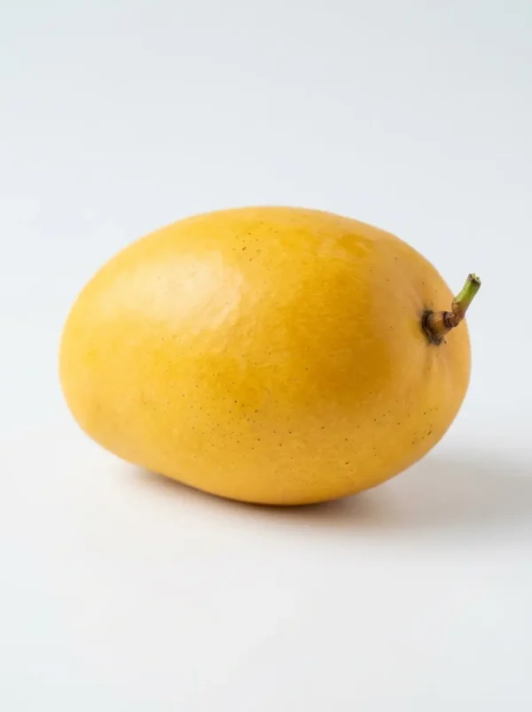 Close-up of Sindhu Mango fruit showing golden-yellow skin and smooth texture.
